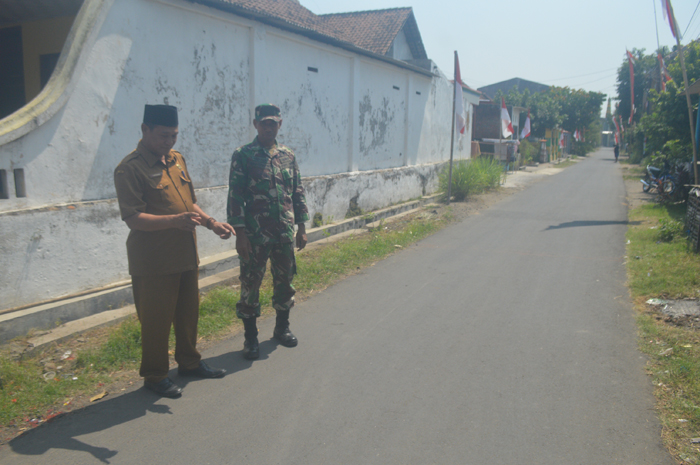 TUNTAS: Kades Ngudirejo Lantarno menunjukkan jalan antar RT yang selesai diperbaiki di Dusun/Desa Ngudirejo, Kecamatan Diwek, Jombang.
