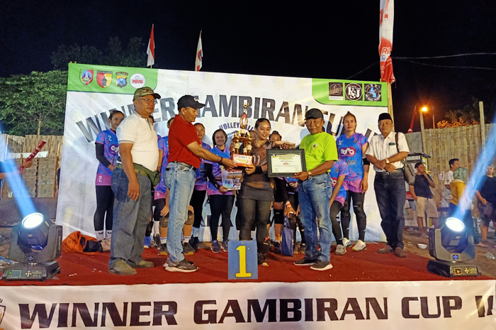 APRESIASI: Camat Mojoagung, Jombang Muchtar (kaos merah) dan Kepala Desa Gambiran Jupri (kaos kuning) menyerahkan trofi juara turnamen bola voli Gambiran Cup II 2024 kepada pemenang (10/8).