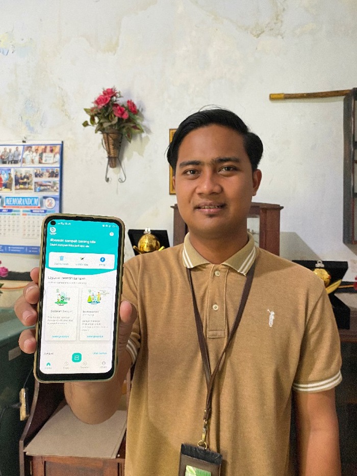 Mochammad Zenrisky Rahmat Hidayah,Kepala Divisi Bisnis Perumda Aneka Usaha Seger Jombang menunjukkan aplikasi Beresin Sampah