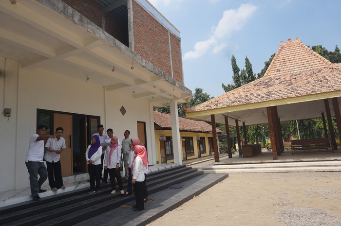 MEGAH: Kepala Desa Banyuarang Achmad Anshori Wijaya berkoordinasi dengan jajaran perangkat desa terkait keberlanjutan proyek pembangunan kantor desa.