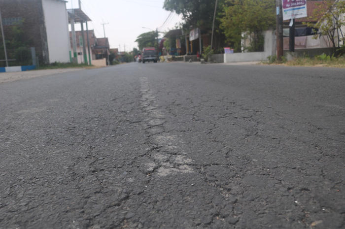 TAK TERLIHAT: Garis marka jalan berwarna putih di Desa Sukorejo, Kecamatan Perak, Jombang mulai pudar.