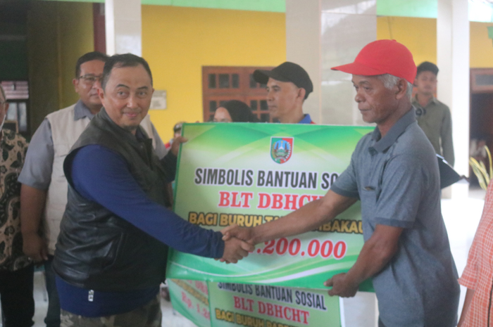 SEMRINGAH: Pj Bupati Jombang Teguh Narutomo simbolis menyerahkan BLT DBHCHT di Balai Desa Bendungan, Kecamatan Kudu, Jombang, Minggu (8/9).