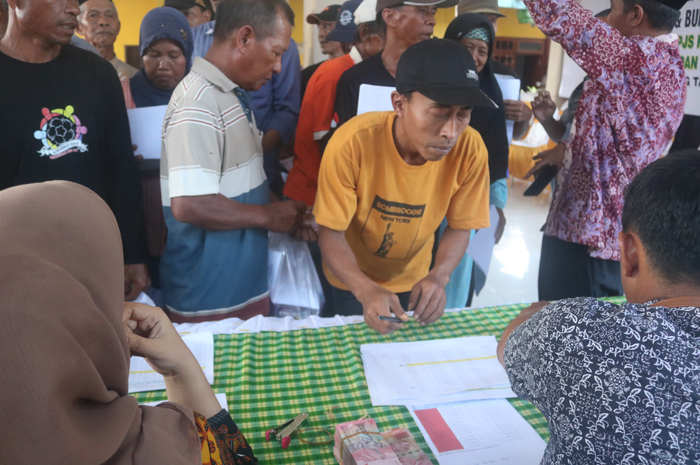 ANTRE: Buruh tani dan buruh pabrik rokok penerima BLT DBHCHT di Balai Desa Bendungan, Kecamatan Kudu, Jombang.