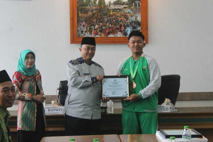 MONCER: Aseldat Jala Badra Trimianto (kanan) menerima piagam penghargaan dari Pj Bupati Jombang Teguh Narutomo usai sukses sabet medali perunggu O2SN di Jakarta (22/8).