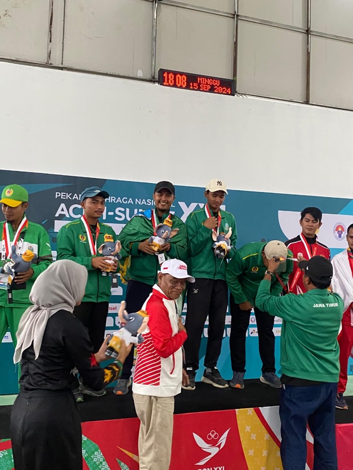 BERPRESTASI: Aris (topi hitam) atlet Jombang ketika menerima medali di PON XXI 2024 Aceh-Sumut.