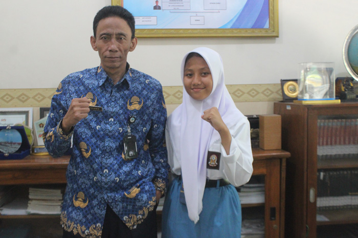 BERPRESTASI: Adine Nabila Ekidya peraih medali PON Aceh Sumut bersama Kepala SMAN 2 Jombang Budiono.