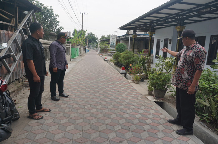 BEBAS KUMUH: Kepala Desa Bongkot Moh. Yahya bersama jajaran perangkat desa saat menunjukkan lokasi pembangunan drainase dan jalan paving di Dusun/Desa Bongkot, Kecamatan Peterongan, Jombang.