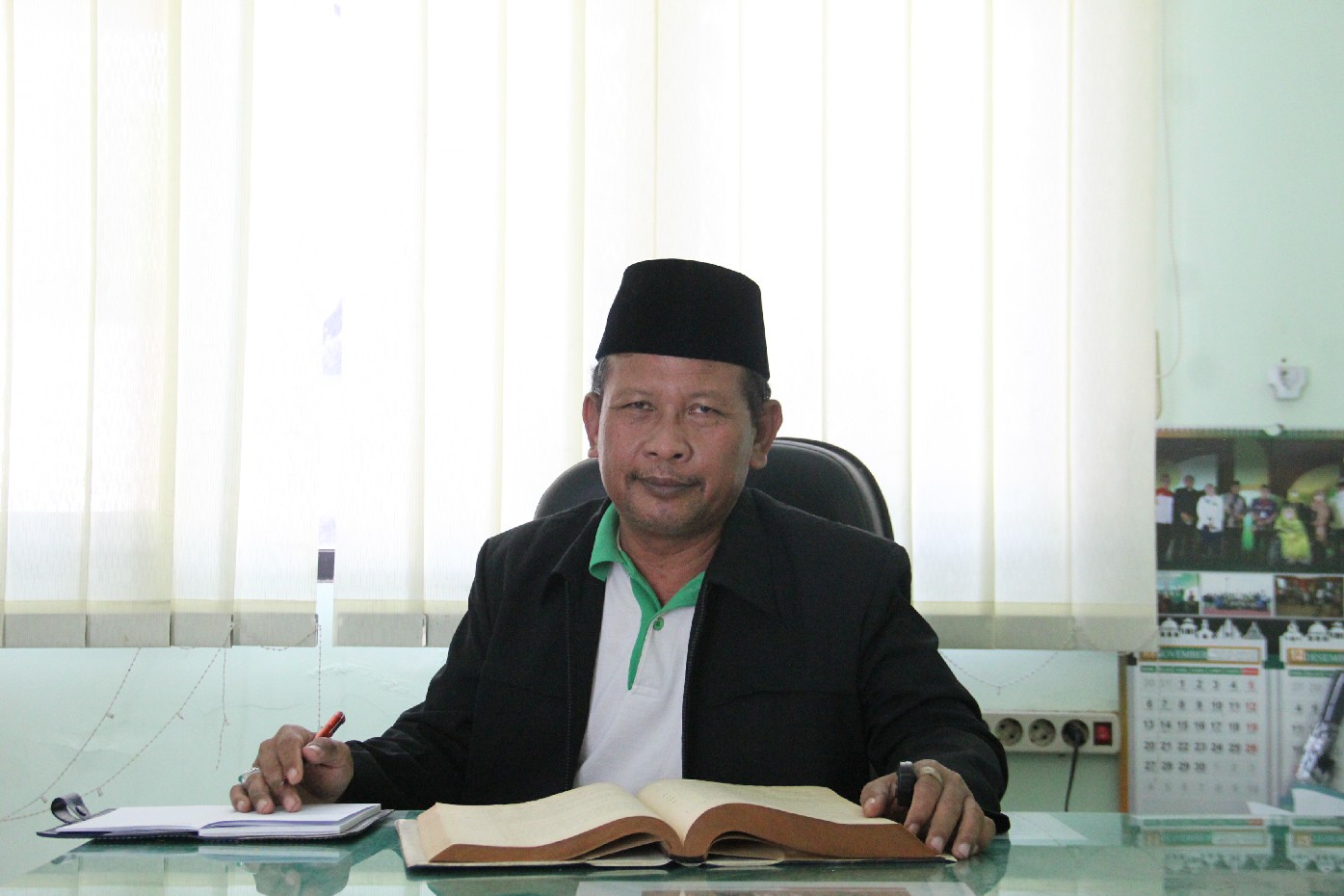 INTELEK: Kepala Seksi Pendidikan Diniyah dan Pondok Pesantren (PD-Pontren) Kemenag Jombang, Drs H Muhammad Agussalim MH, membaca kitab di ruangannya, Jumat (20/9).