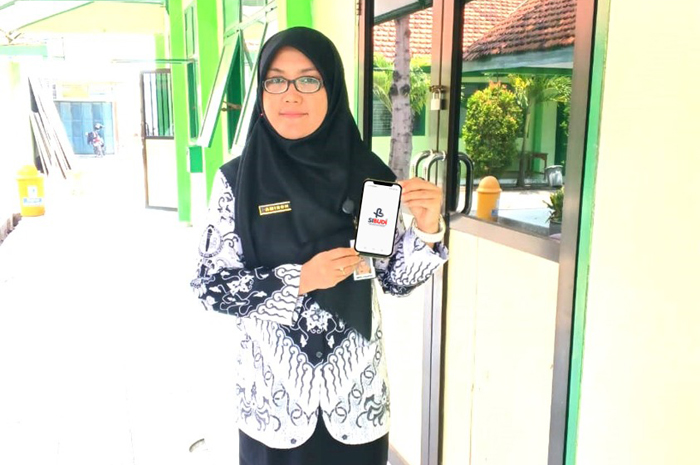 KREATIF:  Kepala SMKN Kudu, Jombang, Amiroh MKom menunjukkan aplikasi Si Budi+.