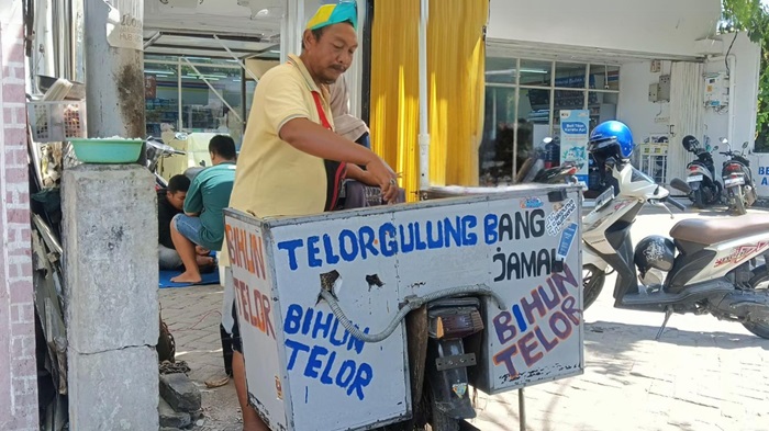 JADI VIRAL: Hasan atau kerap disapa Bang Jamal menjajakan telur gulung di Jalan Arif Rahman Hakim, Jombang.