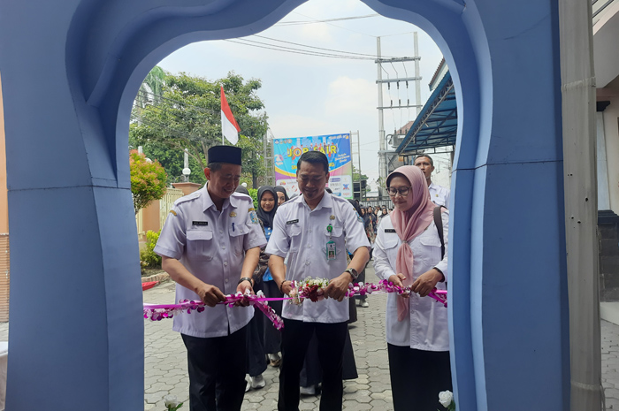 TEROBOSAN: Kasubag TU Cabdindik, Ulil Mu&rsquo;amar, didampingi Kepala SMKN 2 Jombang, Abdul Muntolib, dan Dwi Disetyawati dari Disnaker menggunting pita tanda job fair dimulai (7/10).