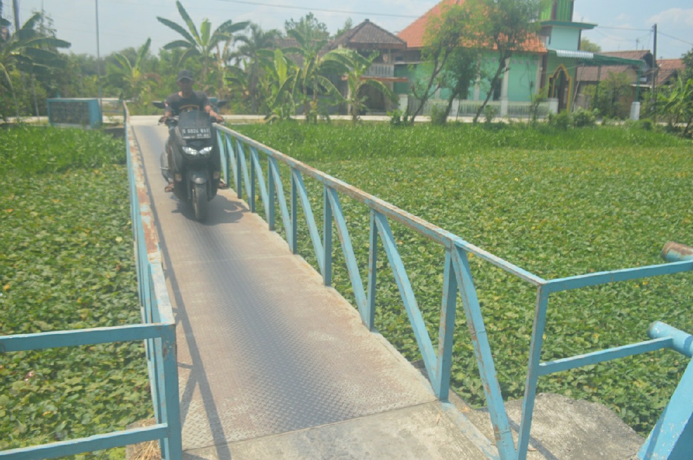 MENYEMPIT: Warga melintas di jembatan darurat Desa Kudubanjar, Kecamatan Kudu, Jombang, (10/10).