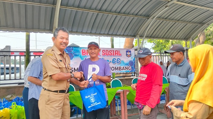 Kepala SMPN 2 Jombang Alim MPd saat menyerahkan bingkisan sembako di acara baksos.