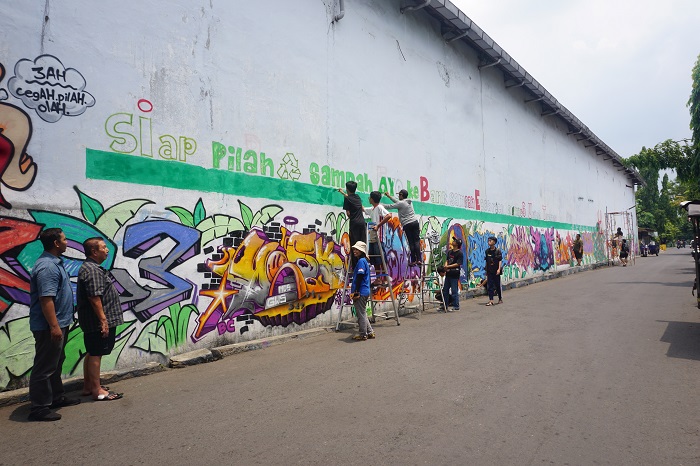 KEREN: Kepala Kelurahan Kaliwungu Ade Yudha Kusuma bersama Ketua RT 05 Kaliwungu Tjandra Iewanto menyaksikan proses pengecatan mural oleh kader lingkungan berkolaborasi dengan Komunitas Sanggar Hijau
