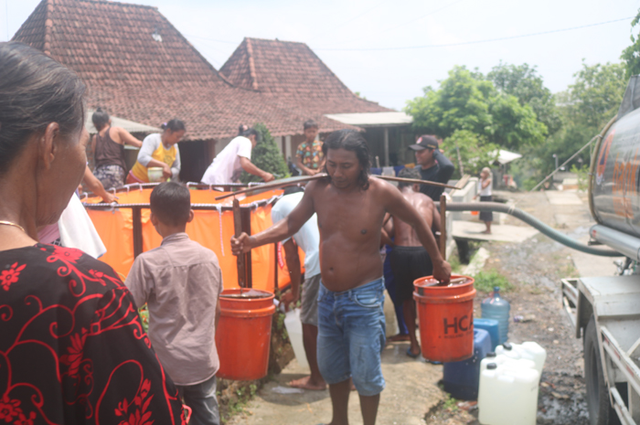 KRISI AIR BERSIH: Warga Desa Manduro, Kecamatan Kabuh, Jombang berebut air bersih suplai dari BPBD, Jumat (22/11).