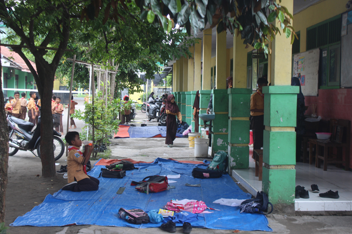 DARURAT: Siswa SDN Jarak 2, Kecamatan Jogoroto, Jombang, belajar di halaman sekolah selama proses rehab belum selesai.