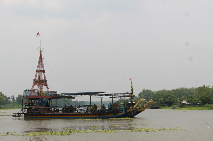 DIPASANG IMBAUAN: Petugas Dishub Jombang saat memasang papan imbauan di wilayah Jasa penyeberangan perahu Sungai Brantas (12/11).