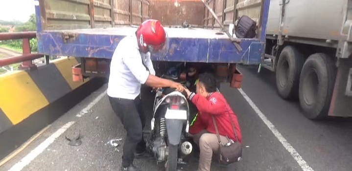 Petugas mengevakuasi motor korban yang menancap di bak truk