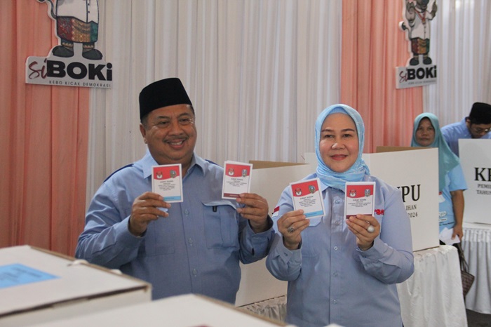 SALURKAN HAK PILIH: Cabup 02 Warsubi didampingi istri dan keluarga nyoblos di TPS 002, Dusun Bulak, Desa Mojokrapak, Kecamatan Tembelang, Jombang, Rabu (27/11).