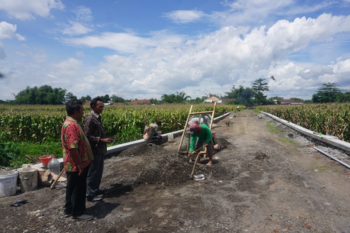 PENUNJANG AKSES WARGA: Kepala Desa Mancar Nur Prasetyo meninjau proses pembangunan TPT di Dusun Mancar Timur.