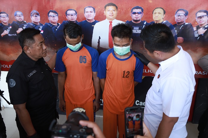 KENAKAN BAJU TAHANAN: Dua tersangka saat diamankan di Mapolres Jombang, Jumat (13/12).
