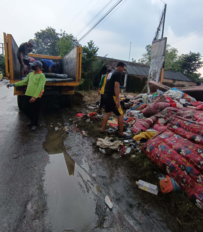 DIANGKUT: Petugas mengangkut sampah sisa banjir di Kesamben, Jombang berupa kasur hingga sofa dan almari.