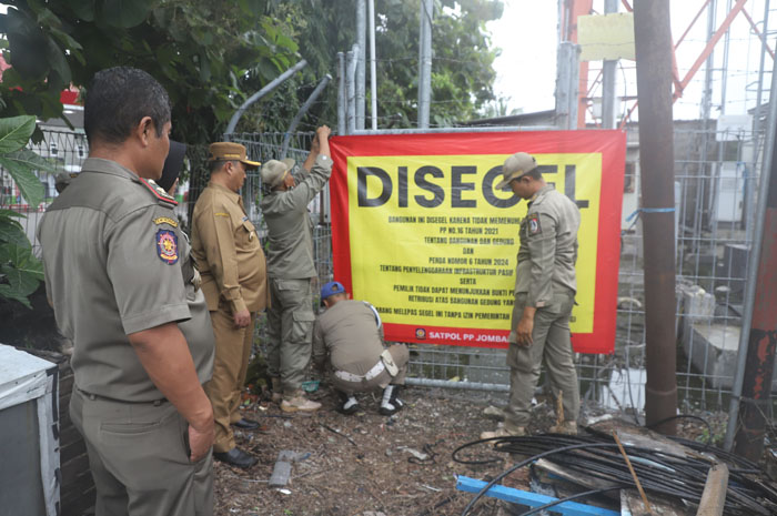 DIPASANG SEGEL: Pj Bupati Jombang Teguh Narutomo saat menyegel tower yang berada di Jl KH Mimbar Desa Sambongdukuh Kecamatan Jombang.