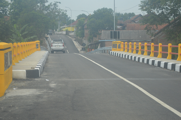 TUNTAS: Warga melintas di jembatan Desa Banjaragung, Kecamatan Bareng, Jombang yang rampung dikerjakan, Rabu (1/1).