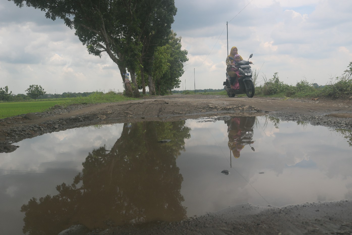 RUSAK BERAT: Jalan kabupaten di Dusun kedunglopis, Desa Rejosopinggir, Kecamatan Tembelang, Jombang jadi kubangan air.