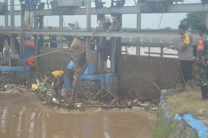 BERJIBAKU: Warga bersama petugas melakukan pembersihan sangkrah di pintu Dam Yani di Desa Budugsidorejo, Kecamatan Sumobito, Jombang yang tak fungsi, Kamis (23/1).