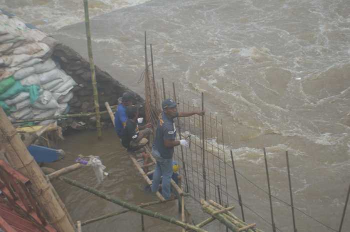 BELUM TUNTAS: Sejumlah pekerja melakukan penanganan darurat tanggul atau sayap Dam Balongsono di Desa Talunkidul, Kecamatan Sumobito, Jombang yang longsor.