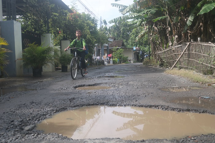 RUSAK: Kondisi jalan di Dusun Candi, Desa Sidomulyo, Kecamatan Megaluh, Jombang, jadi kubangan air (22/1).