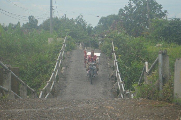 NEKAT: Sejumlah warga melintas di jembatan Desa Barongsawahan, Kecamatan Bandarkedungmulyo, Jombang yang kian melengkung (22/1).
