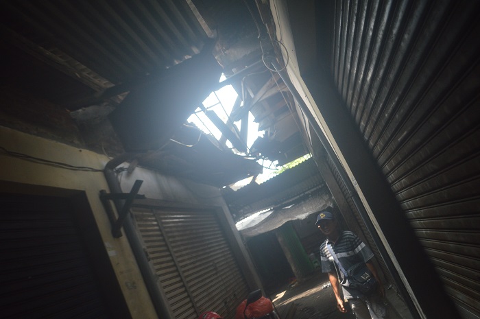 RUSAK: Salah seorang pedagang menunjukkan atap dan talang air Pasar Peterongan, Jombang yang rusak, Senin (24/2).