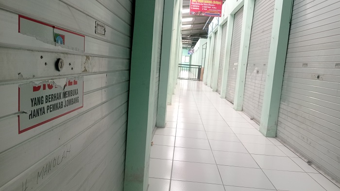 TUTUP: Stiker segel yang dipasang Pemkab Jombang di kios Pasar Perak mulai rusak.