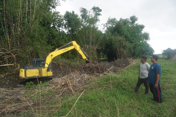 PENGERUKAN SUNGAI: Kepala Dusun Watugaluh Wawan Budiono bersama petugas Dinas PUPR Kabupaten Jombang saat mengawasi pekerjaan normalisasi sungai di saluran afvoer Jasem.