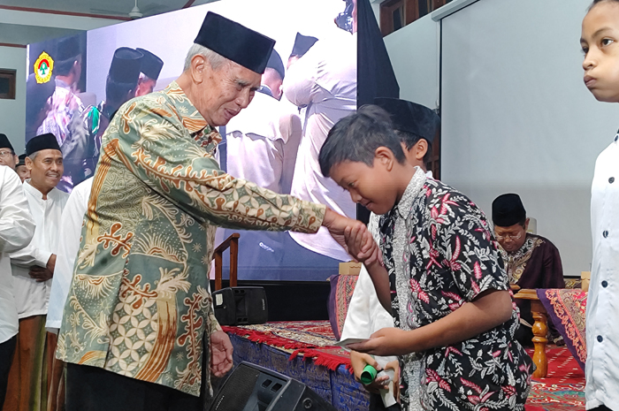 PEDULI: Pimpinan Ponpes Gadingmangu Perak KH Basiya Adhi Banadi (pakaian batik) menyerahkan santunan kepada anak yatim.