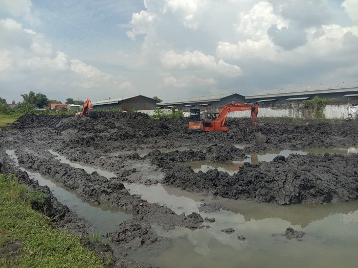 DIKERUK: Petugas menormalisasi sedimentasi embung Dusun Tunggul, di Desa Tunggorono, Kecamatan Jombang.