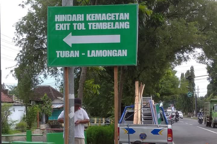 DIPASANG: Petugas memasang rambu petunjuk jurusan terbuat dari banner di jalur alternatif mudik dan balik Lebaran.