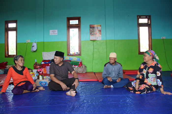 DITEMANI RADIO: Sartini, 68, dan Joyo, 70, saat mendengarkan radio lawas di Posko pengungsian Desa Sambirejo Kecamatan Wonosalam, Jombang, (3/4).