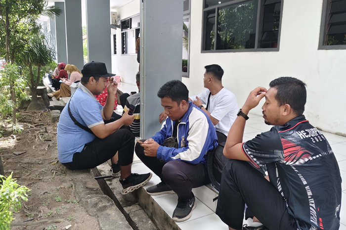 Guru ngemper di teras gedung pembinaan ketenagaan Dinas P dan K Jombang untuk memperjelas status TPG, Senin (21/4).