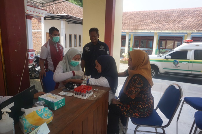 PROGRAM STRATEGIS NASIONAL: Kepala Desa Sumberjo Suti mendampingi warga saat pemeriksaan kesehatan gratis di pendopo kantor Desa Sumberjo, Kecamatan Plandaan, Jombang.