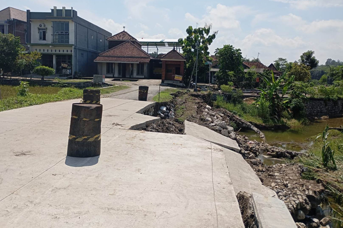 RUSAK: Kondisi tembok penahan jalan beserta cor jalan di Desa Asemgede, Kecamatan Ngusikan, Jombang yang ambrol, Minggu (18/5).