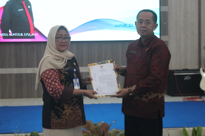 SERAH TERIMA: Penyerahan SK Gubernur Jatim yang diberikan Evi Dwi Widjajanti Plt kepala Cabdindik Wilayah Kabupaten Jombang kepada Muntolib kepala SMKN 1 Jombang.