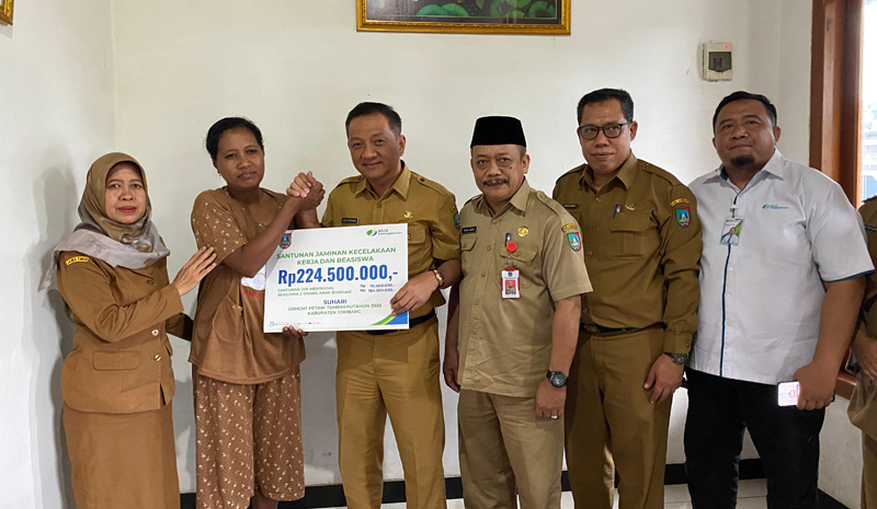 PEDULI: Kepala Kantor BPJS Ketenagakerjaan Cabang Jombang, Ibrahim Hadi Wibowo, mendampingi Sekdakab Jombang, Agus Purnomo, saat menyerahkan santunan JKK dan beasiswa, Senin (26/5).
