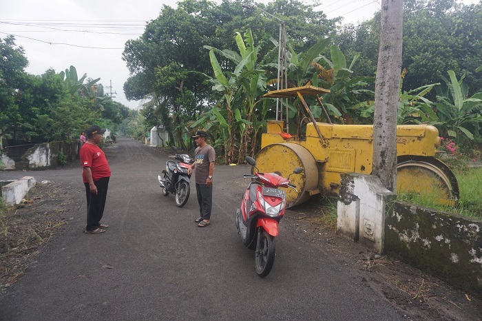 MULUS: Kepala Desa Wuluh H. Roni berkoordinasi dengan Ketua TPK Desa Wuluh Nasrul saat mengecek pembangunan jalan lingkungan di Dusun Babadan, Desa Wuluh, Jombang.