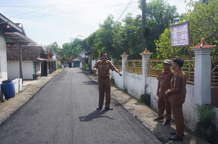 MULUS: Kepala Desa Mojojejer, Mojowarno, Jombang, Putut Sulistiono berkoordinasi dengan perangkat desa saat melakukan pengecekan akhir kondisi jalan lingkungan yang baru selesai dibangun.