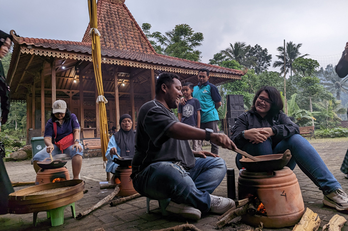 SENSASI TRADISIONAL: Para wisatawan merasakan sensasi hidup di pedesaan dengan menyangrai kopi secara manual di Kampung Adat Segunung, Wonosalam, Jombang.