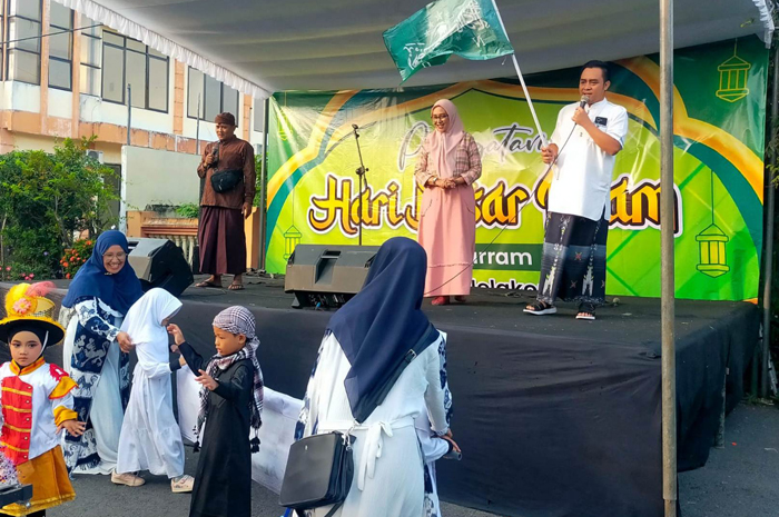 MERIAH: Kepala Kelurahan Jelakombo, Jombang Antin Sukma Utami mendampingi Sekcam Jombang Yudha Asmara saat memberangkatkan peserta pawai taaruf, Sabtu (28/6) pagi.