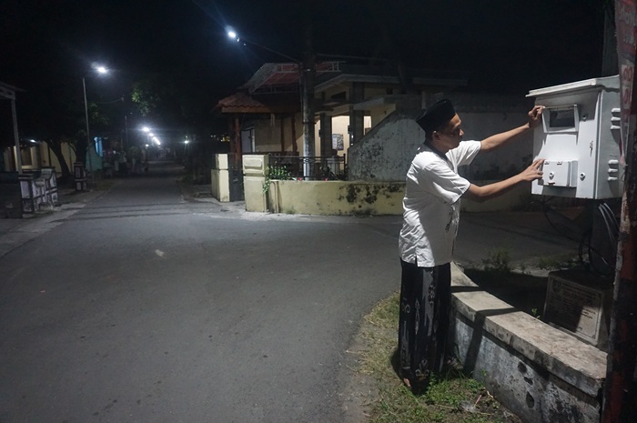 TERANG: Kepala Desa Dukuhklopo, Peterongan, Jombang Saiful Anam mengecek central panel box PJU di Dusun Penjalinan.